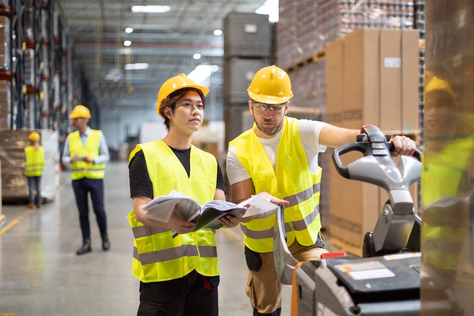 Employees consult while working in the warehouse